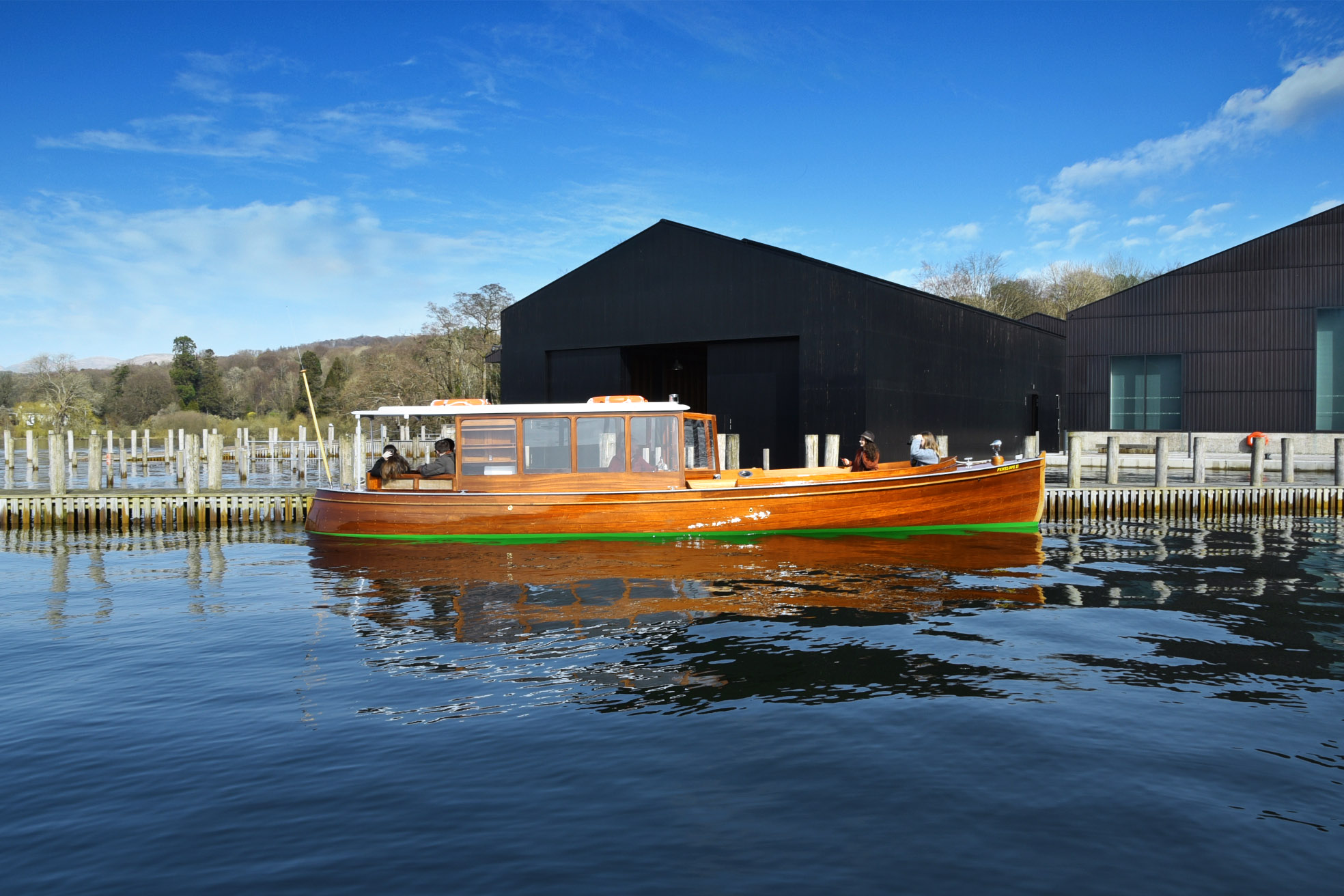 Restored historic wooden boat Penelope II on the water at Windermere Jetty Museum