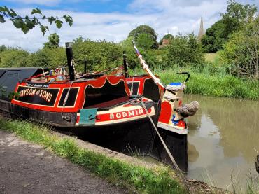 Bodmin's stern, moored alongside a canal bank, whilst attending Braunston Historic Boat Rally in 2023 