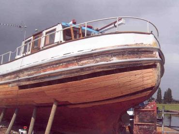 Jean Adair in boatyard undergoing timber repair work to hull