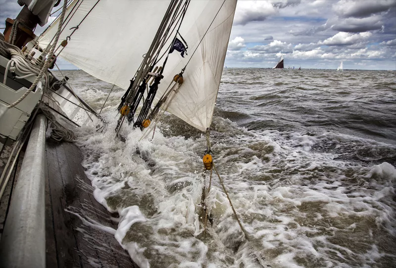 Water flowing over the port side gunnels on a heavily listing ship