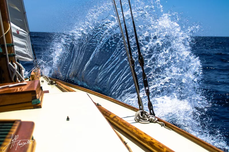Water splashing into the air against the starboard bow, viewed from the deck