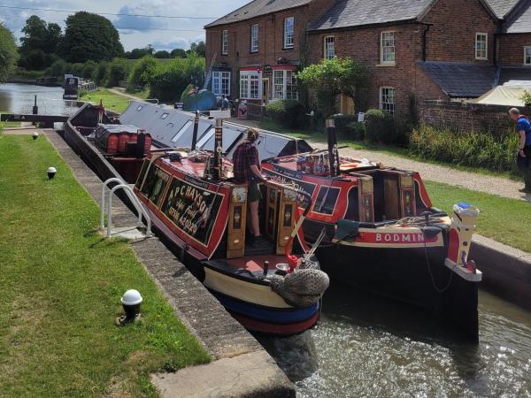 Bodmin (right) paired with Tadworth (left) going through a lock, whilst attending Braunston Historic Boat Rally in 2023