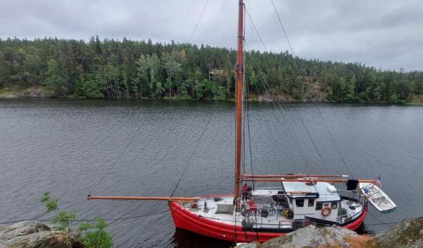 S/V Kess moored against rocky shore