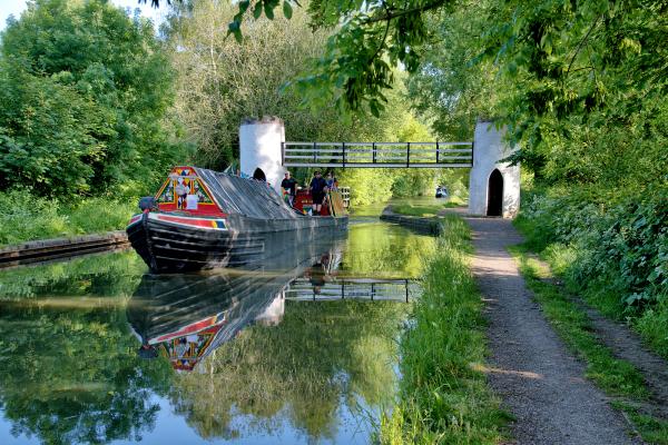 Narrow boat 'England' (known as 'Germany' until the outbreak of WW1) passing the unusual Drayton Manor Footbridge along the Birmingham & Fazeley Canal.