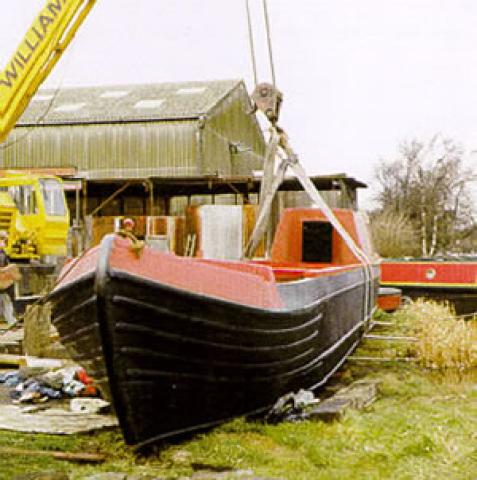 MINNOW - hull restored being lifted back into water. Port bow looking aft.