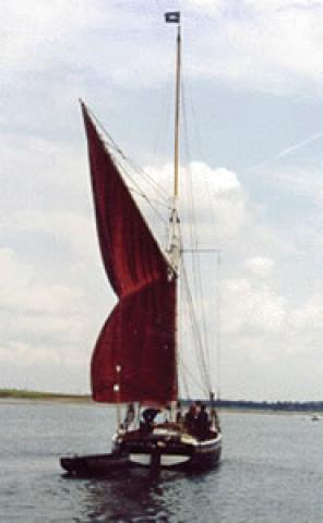 DORIS - under sail. Stern looking forward with tender in tow.